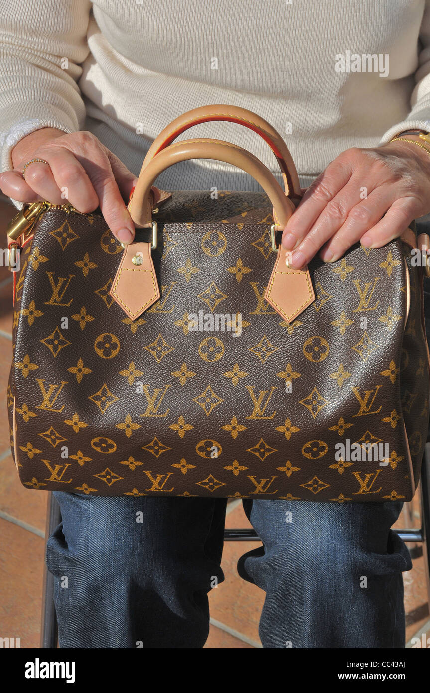 Premium Photo  A woman is holding a bag with the words  louis vuitton   on it.