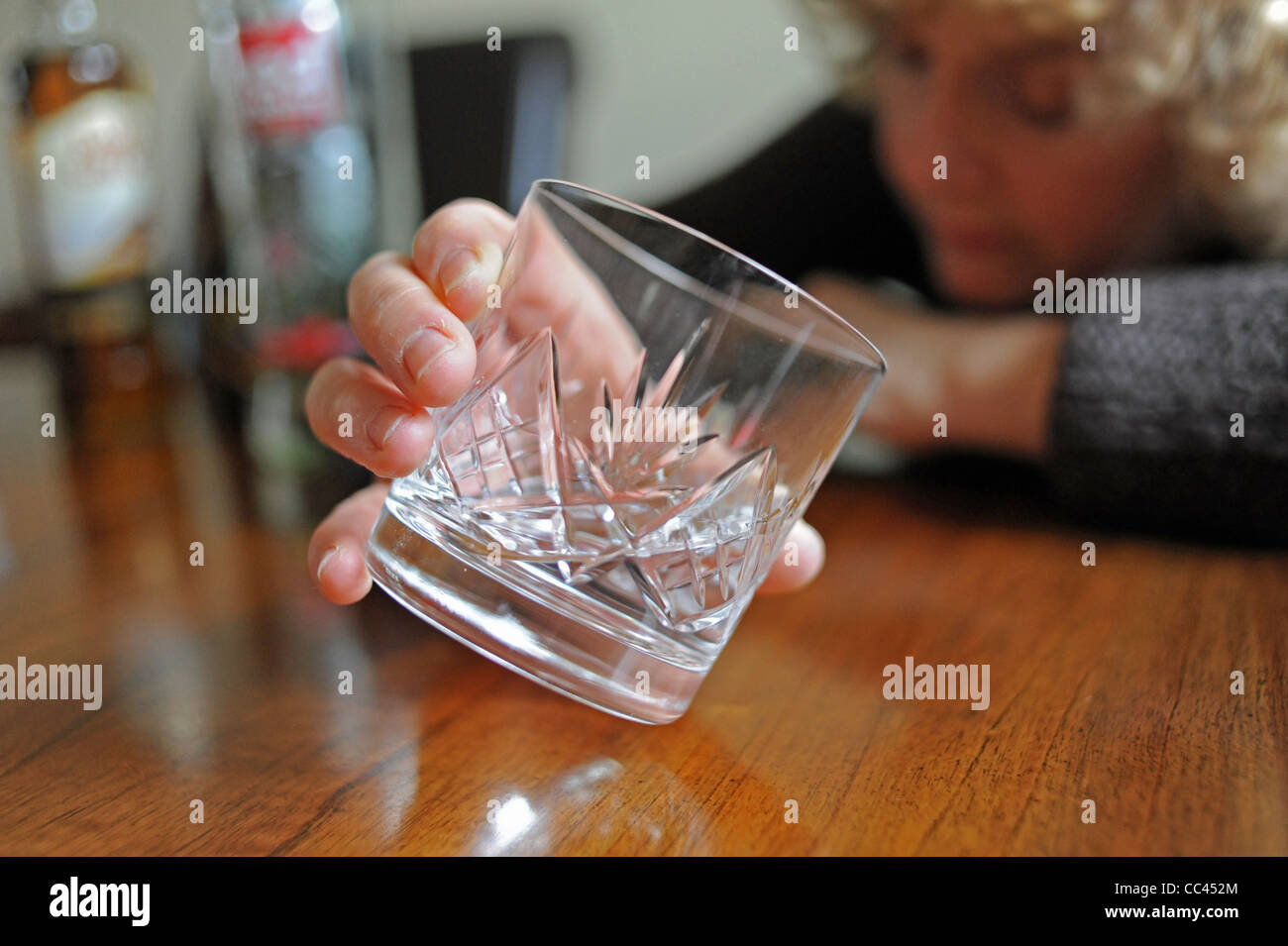 Middle aged woman drinking too much Vodka during the day to illustrate
