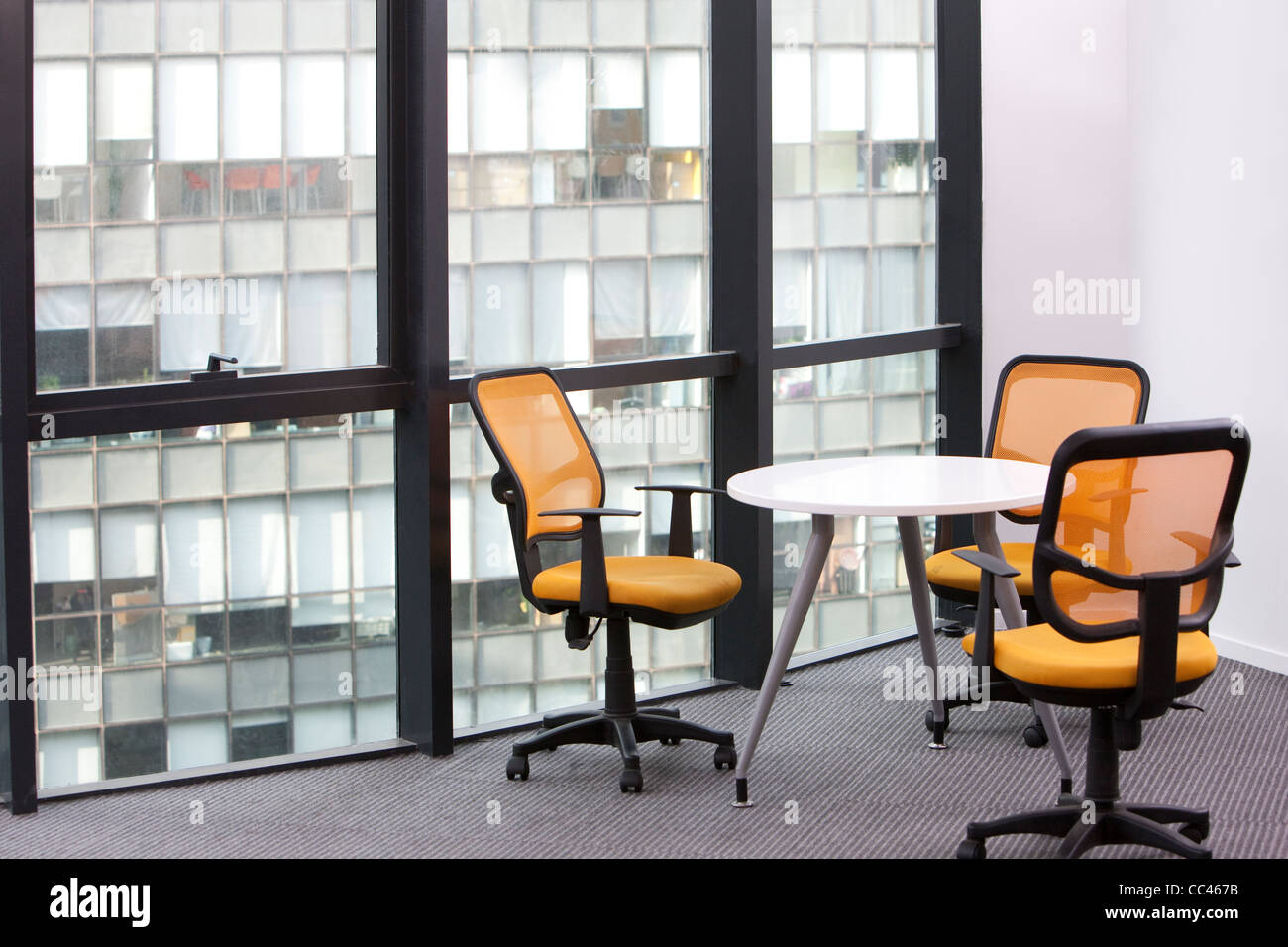 Office swivel chairs by windows and a table Stock Photo