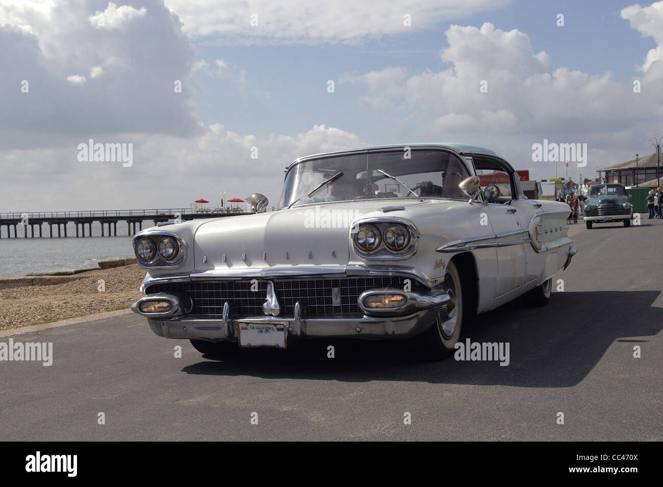 A lovely 1958 Pontiac Star Chief cruises along the seafront at Folkestone during the rally in 2011.The pier is in the background Stock Photo