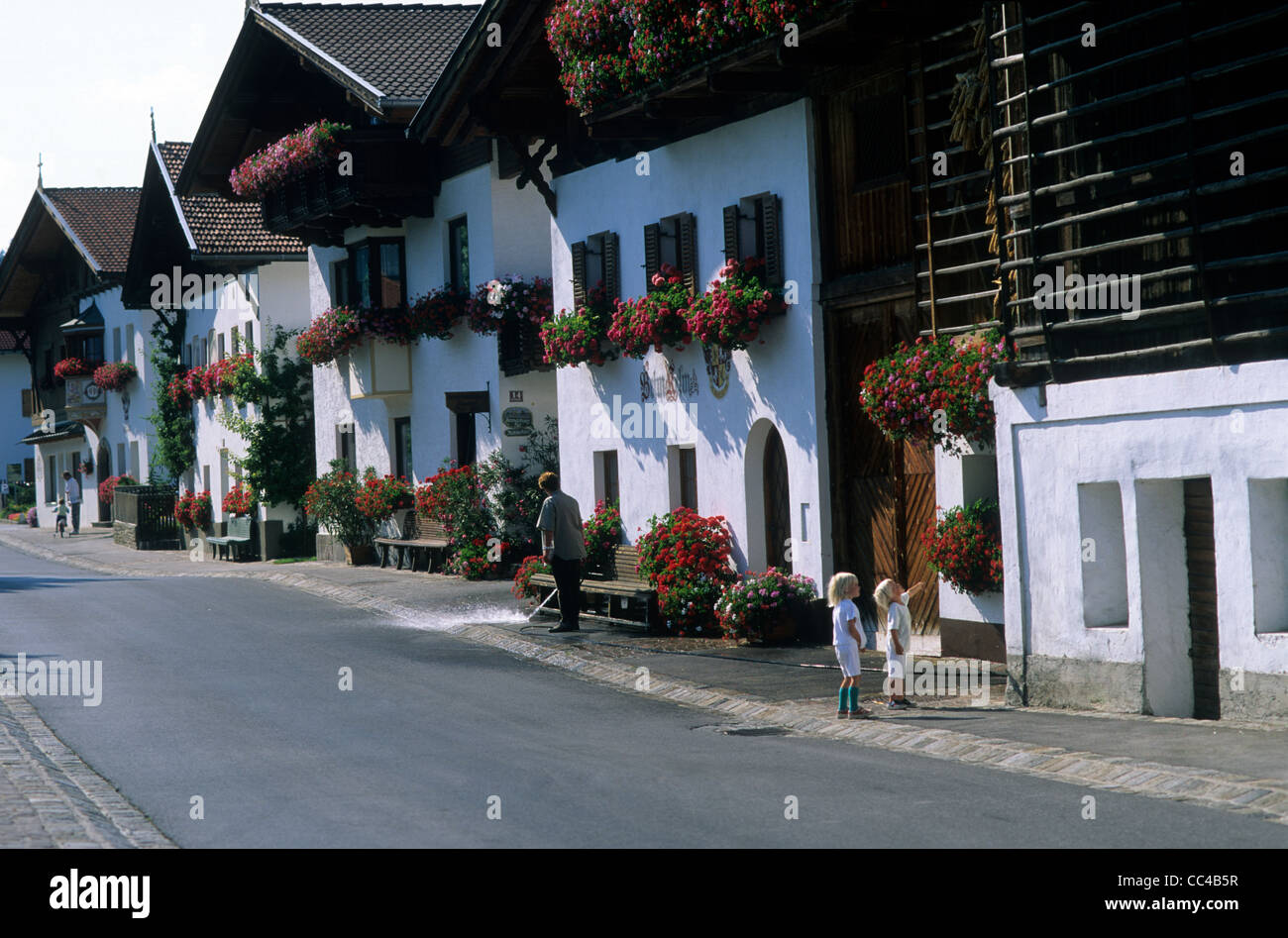 Austria, Austrian, Tirol, Mutters, the main street lined with traditional houses displaying flower boxes in full bloom. Stock Photo