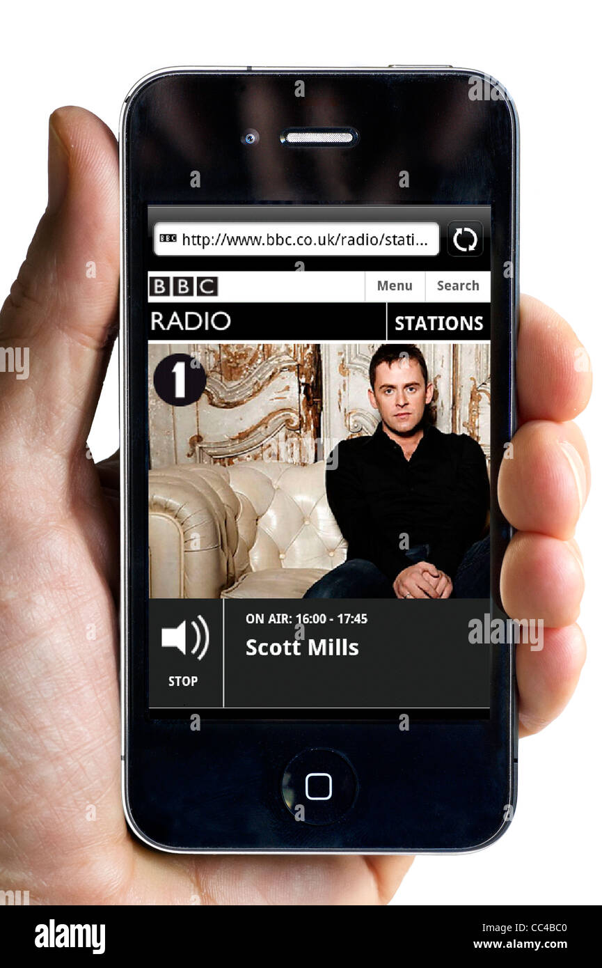 Listening to BBC Radio 1's Scott Mills streaming on an Apple iPhone 4 smartphone Stock Photo