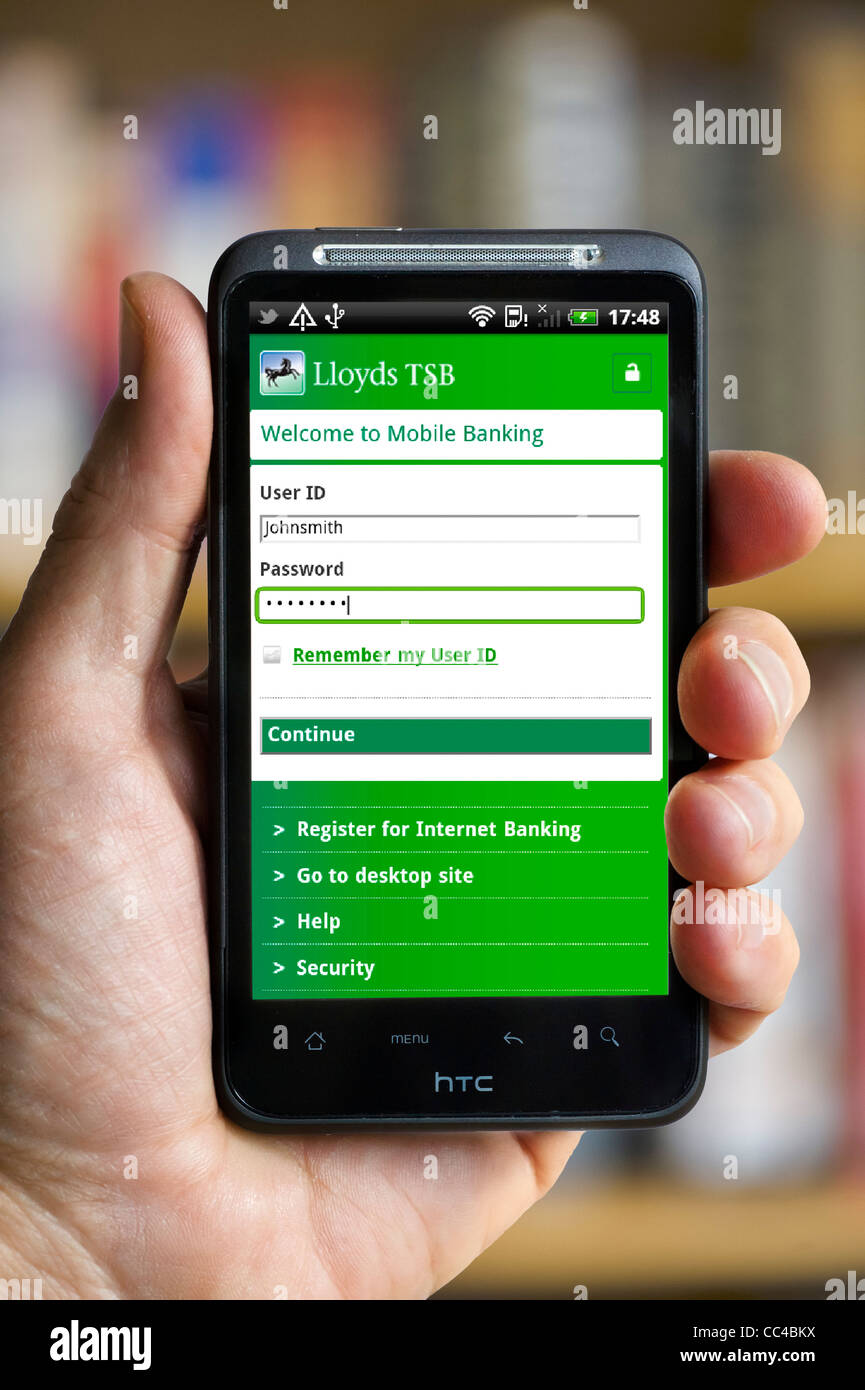 Logging on to mobile banking with the Lloyds TSB app on an HTC smartphone Stock Photo