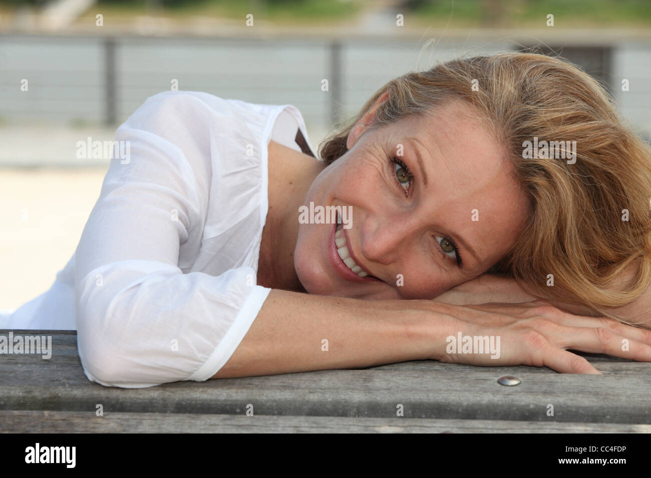 Closeup of a smiling woman sitting outdoors Stock Photo