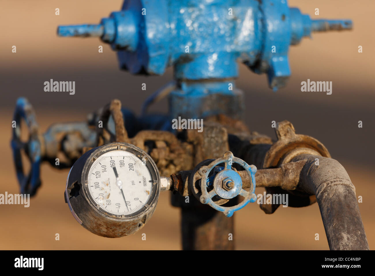 Close up of a gauge and valves on an oil well head on an oil well on