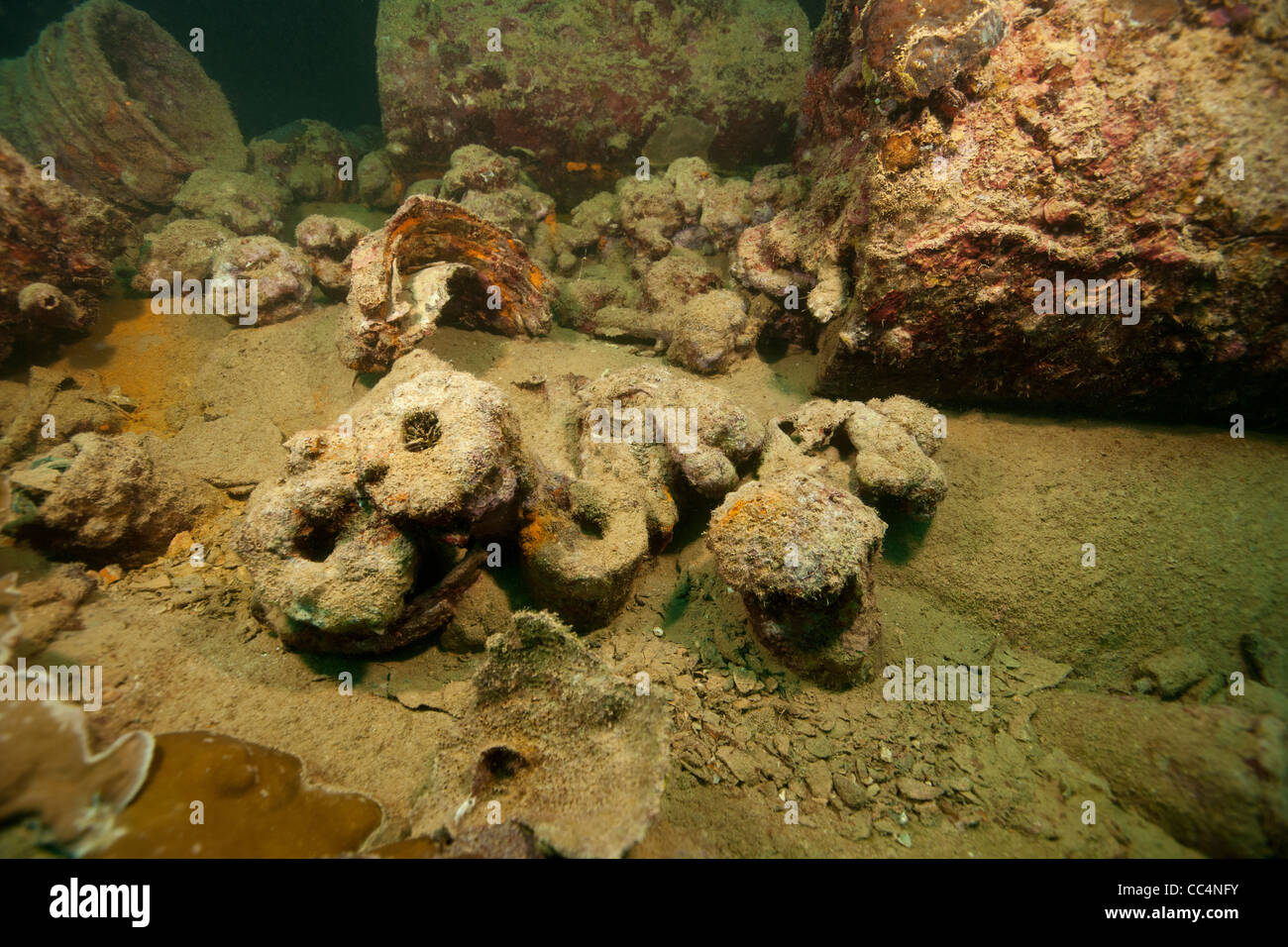 Depth charges, helmets, and other artifacts scattered amongst the ruins of the Helmut Wreck Stock Photo
