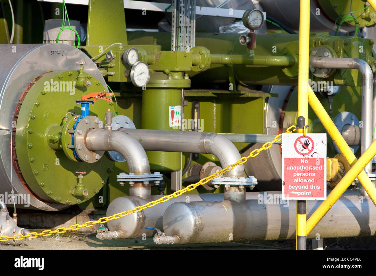 Green Industrial Boilers and Pipework with Warning Sign Stock Photo