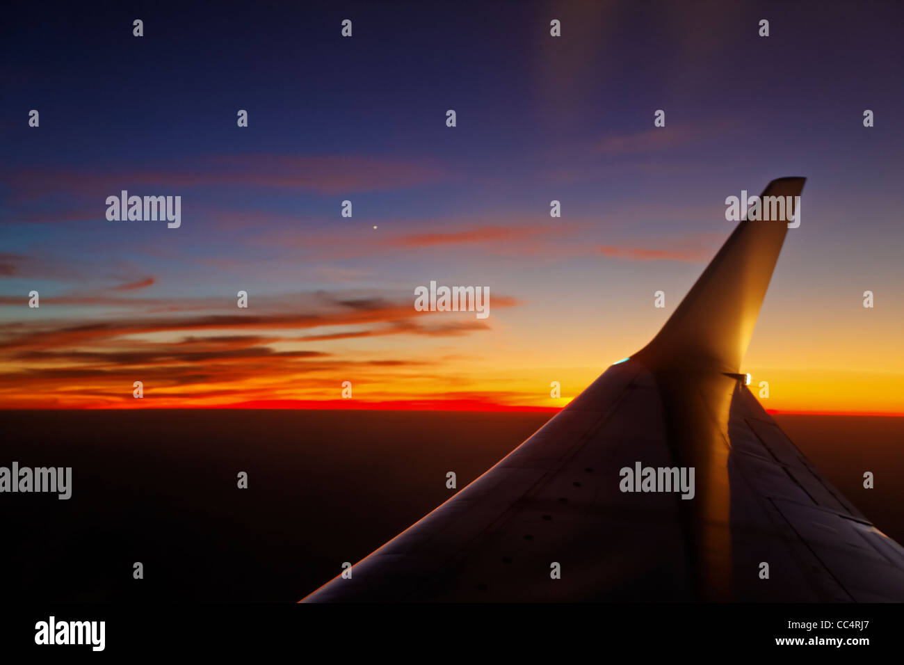 Horizontal, landscape of sundown over clouds of Asia flash cut by airoplane wing, colors, texture Stock Photo