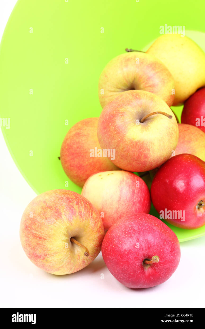 Fresh green, red apples in basket isolated over white background. Stock Photo