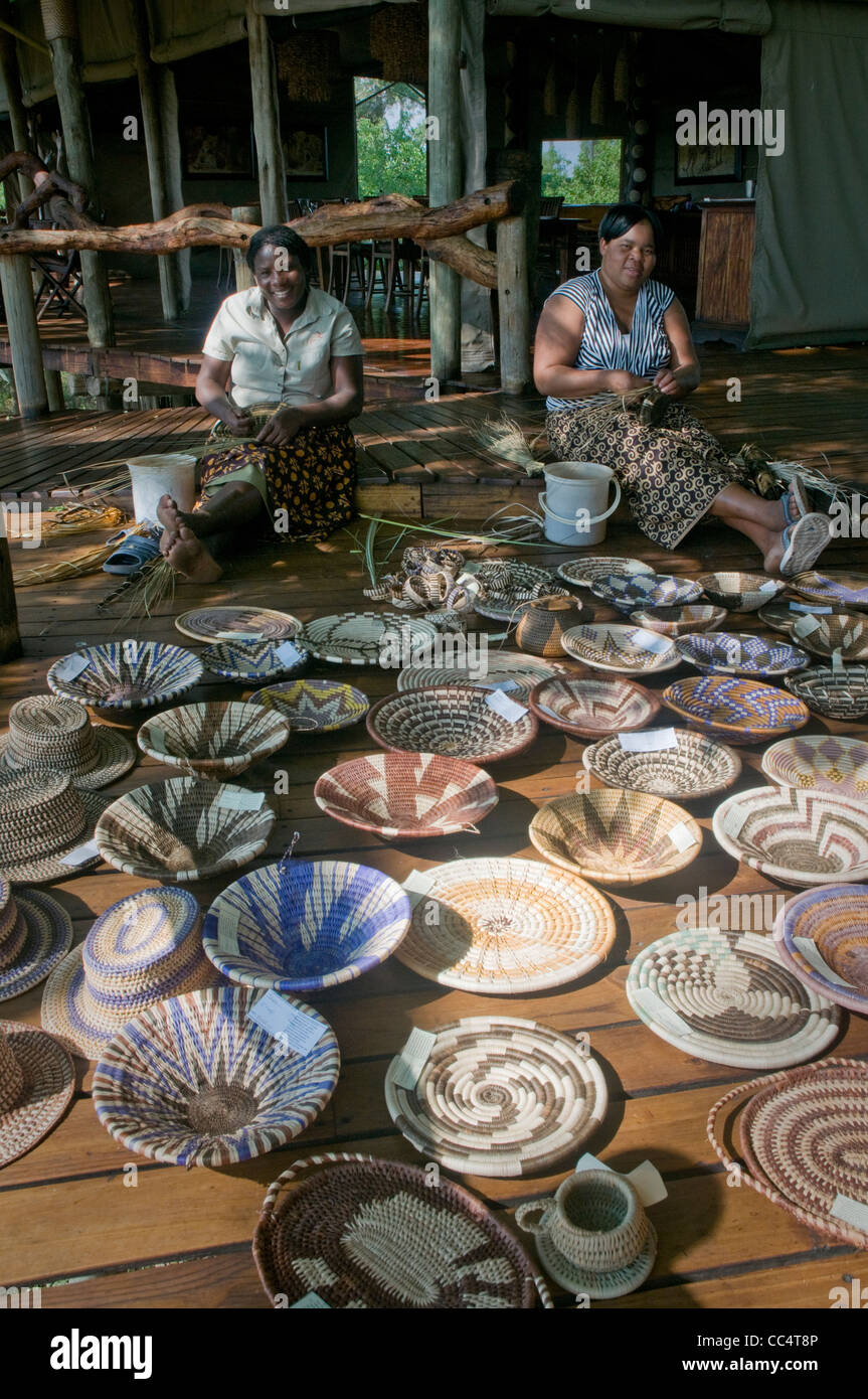 Africa Botswana Tuba TreeWomen weaving baskets, showing baskets in