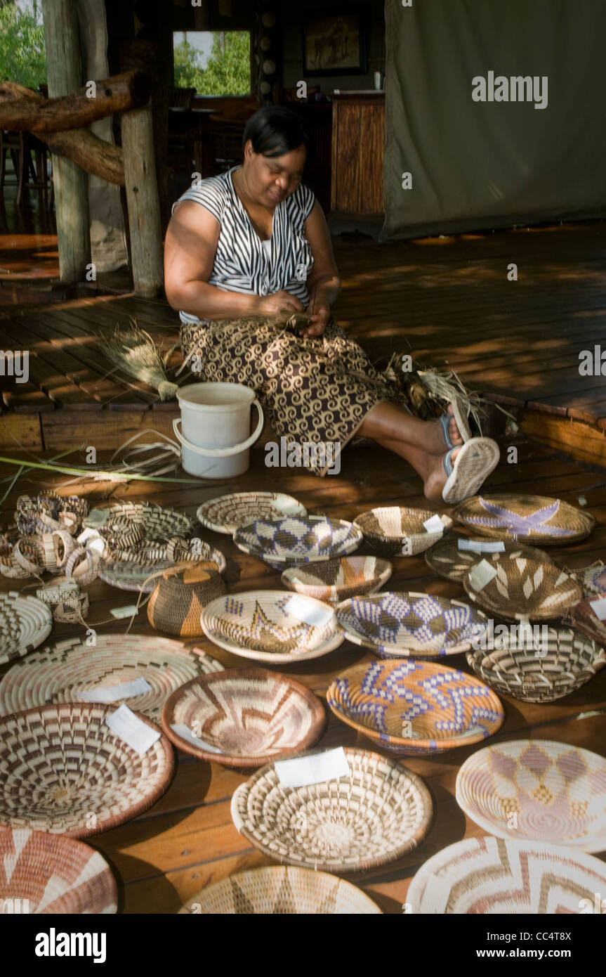Africa Botswana Tuba TreeWoman weaving basket, showing baskets in