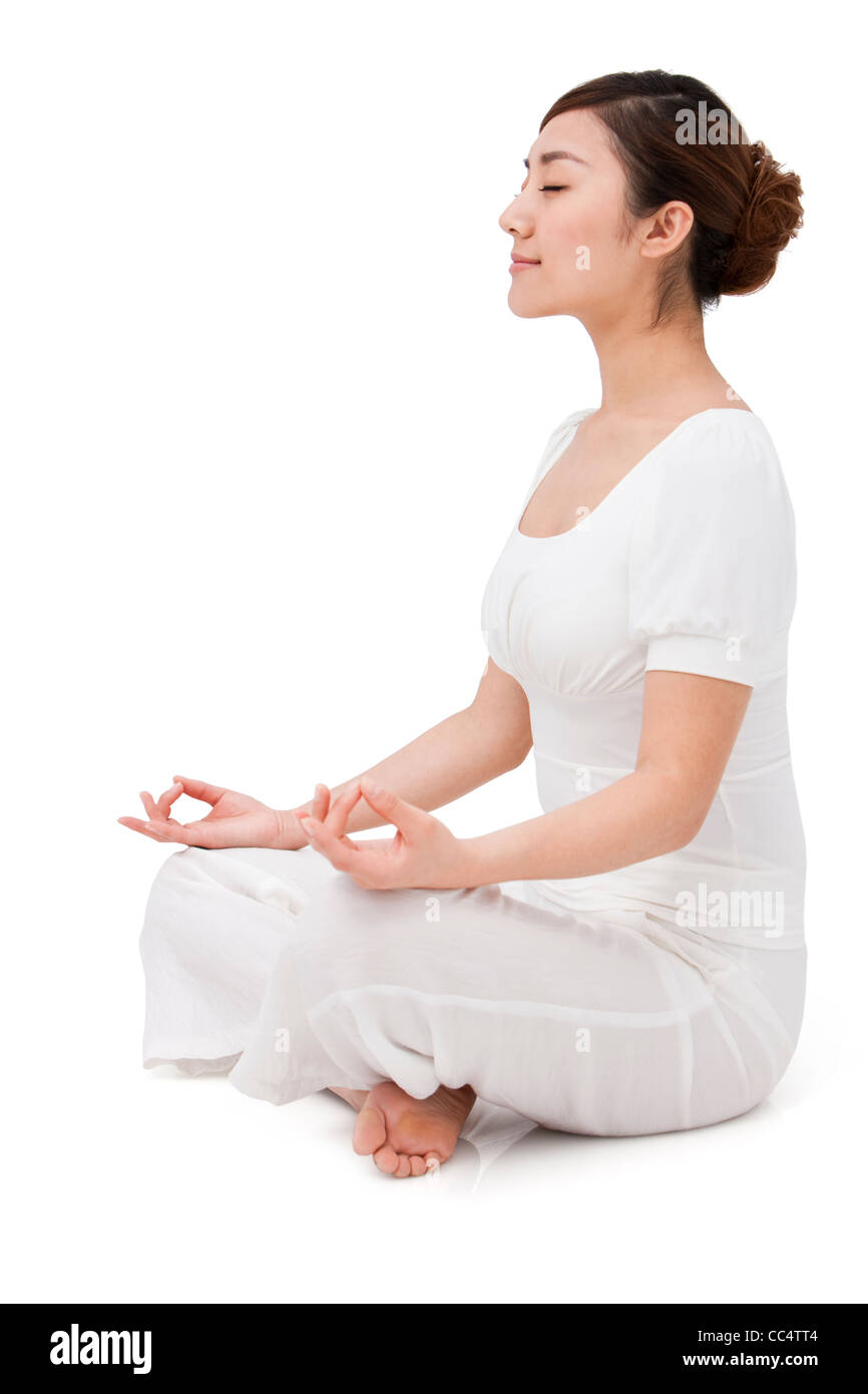 Young woman sitting and meditating Stock Photo - Alamy