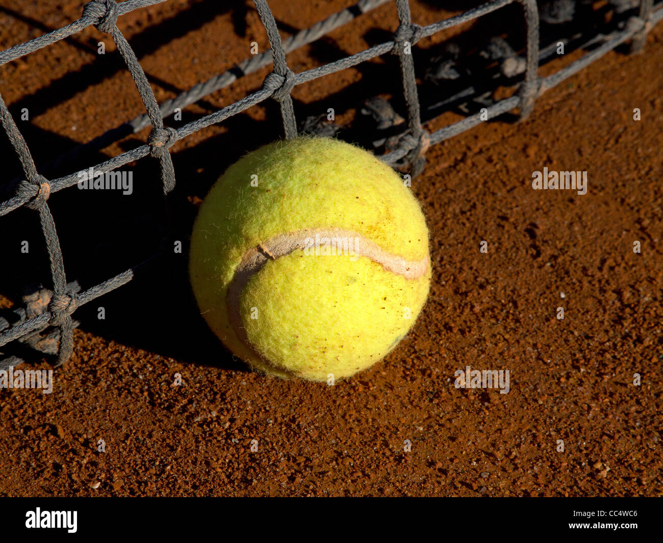 tennis ball on the ground near the net Stock Photo