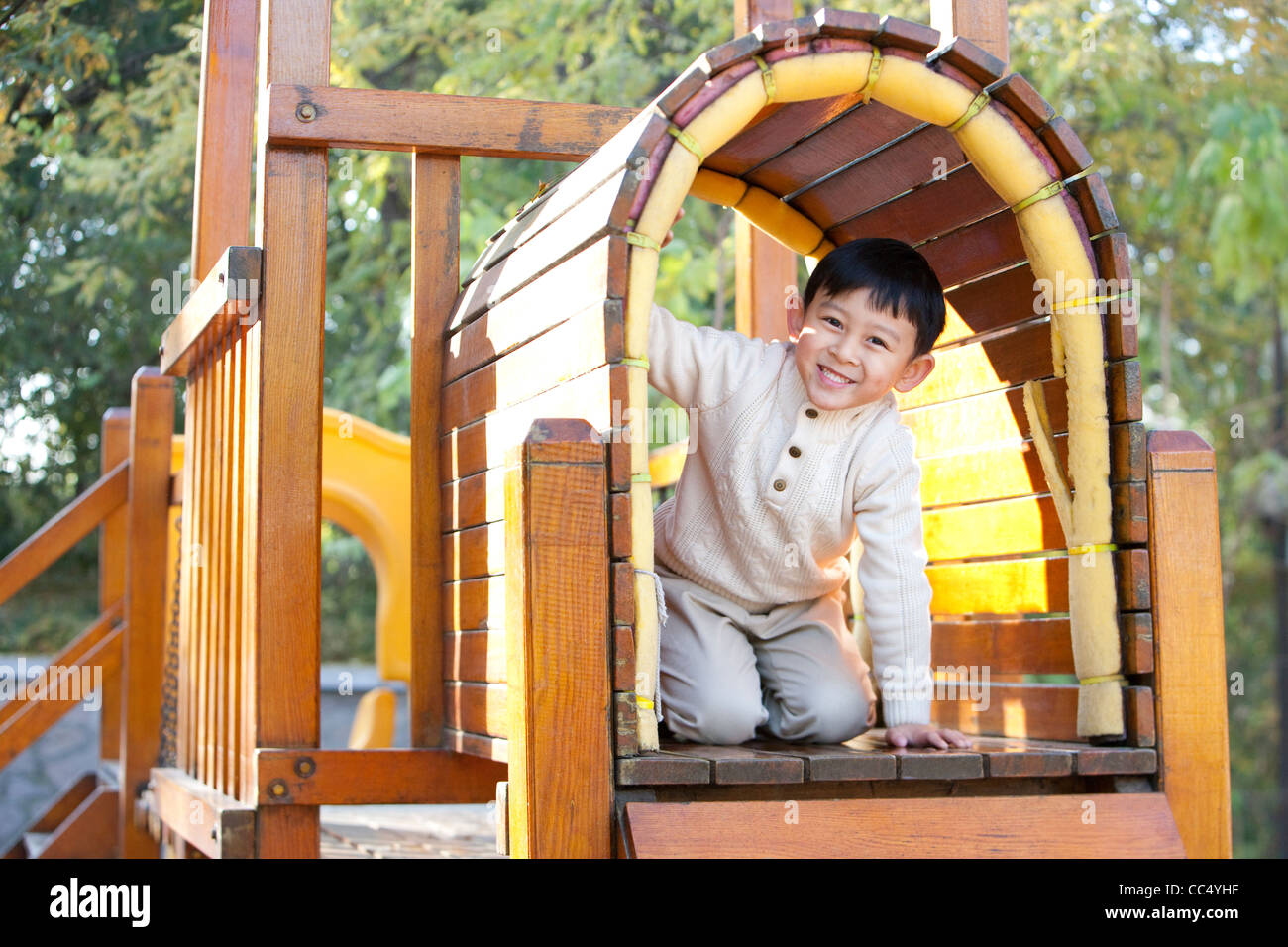 Boy crawling through tunnel in playground Stock Photo Alamy