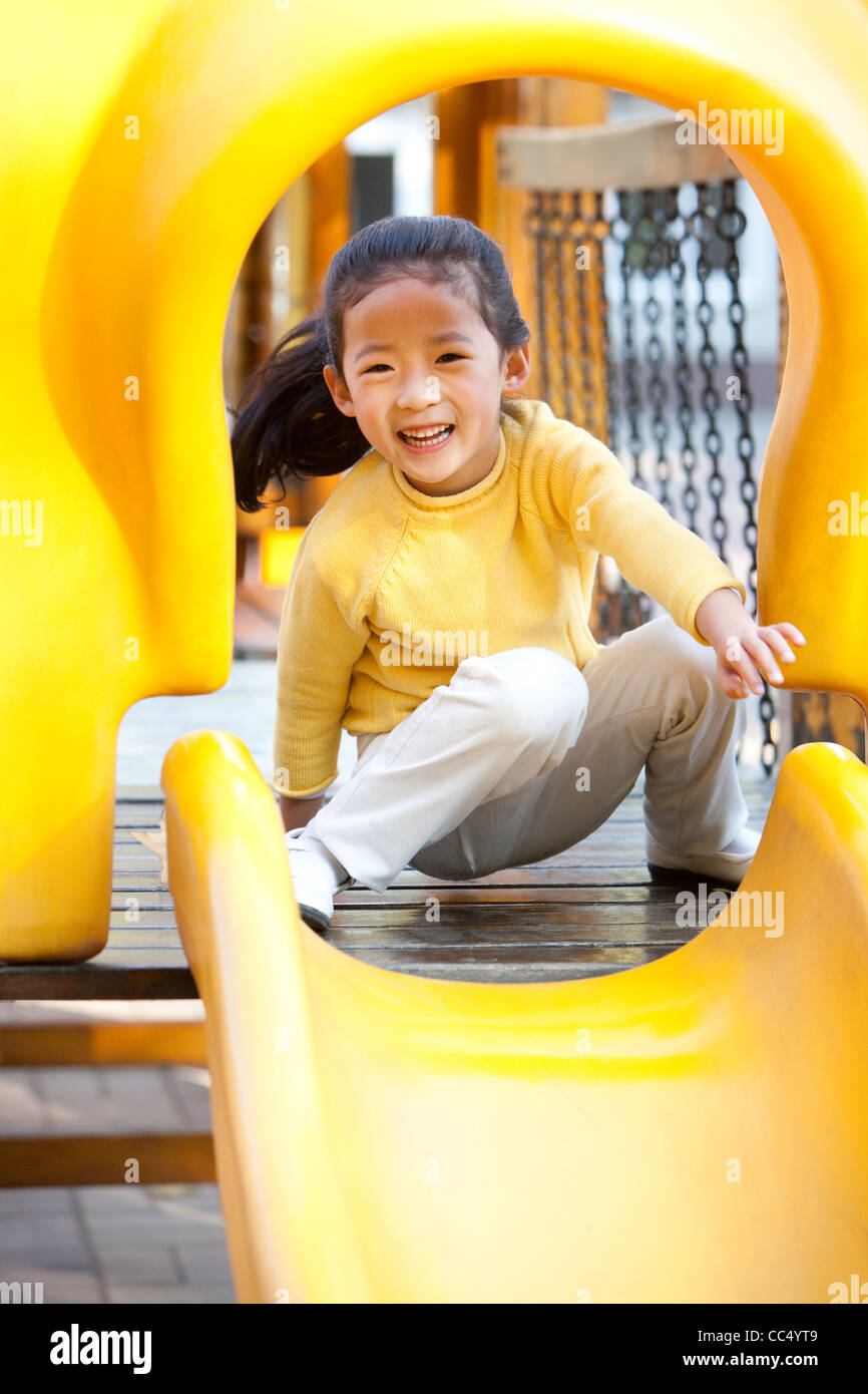 Girl playing on playground slide Stock Photo - Alamy