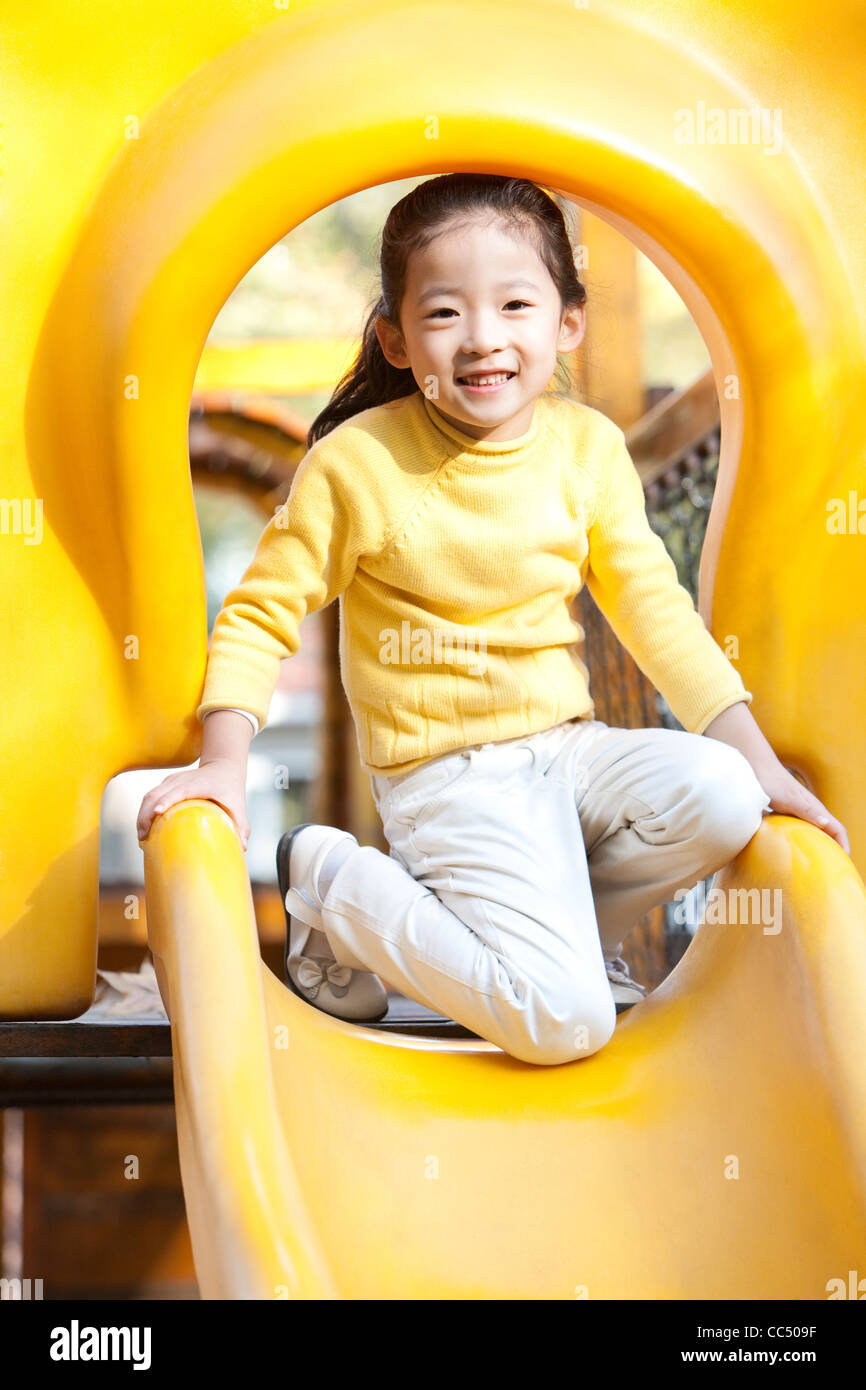 Girl playing on playground slide Stock Photo - Alamy