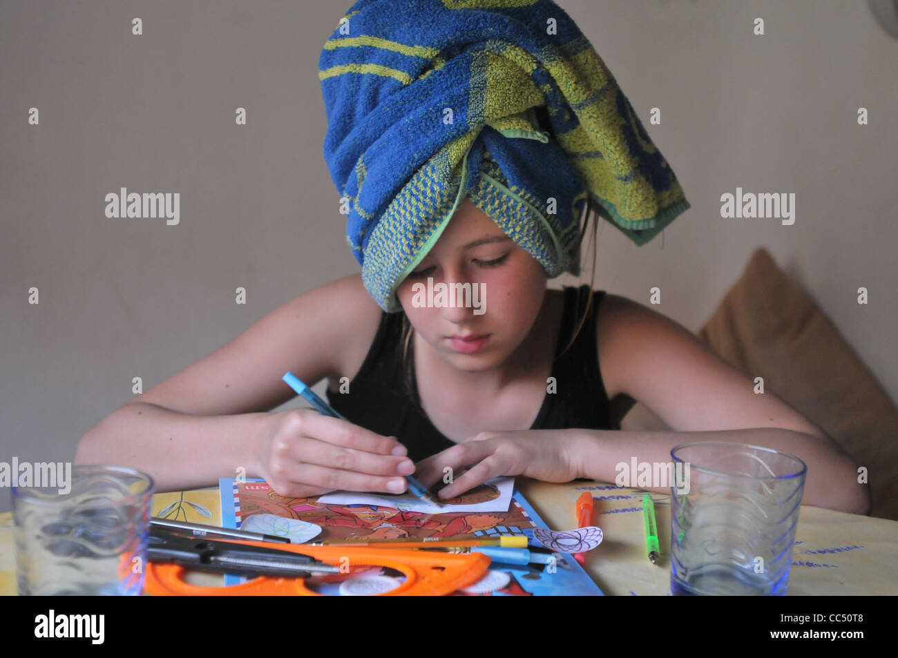 A n 11 year-old girl drawing having just had a shower. Stock Photo