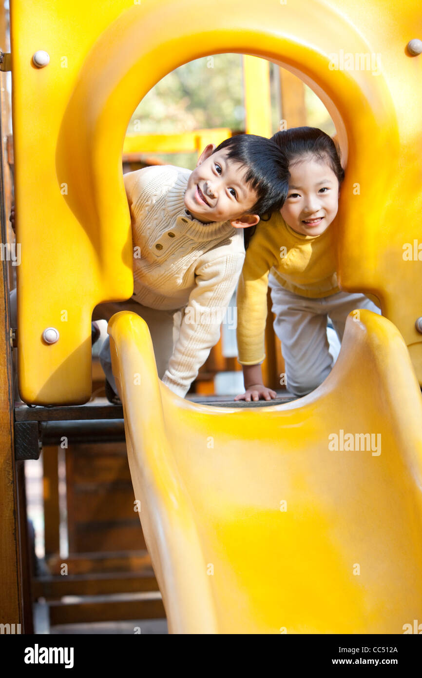 Children playing on playground slide Stock Photo