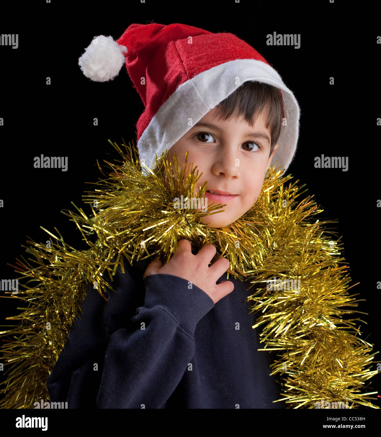 Boy wearing Santa hat with tinsel Stock Photo