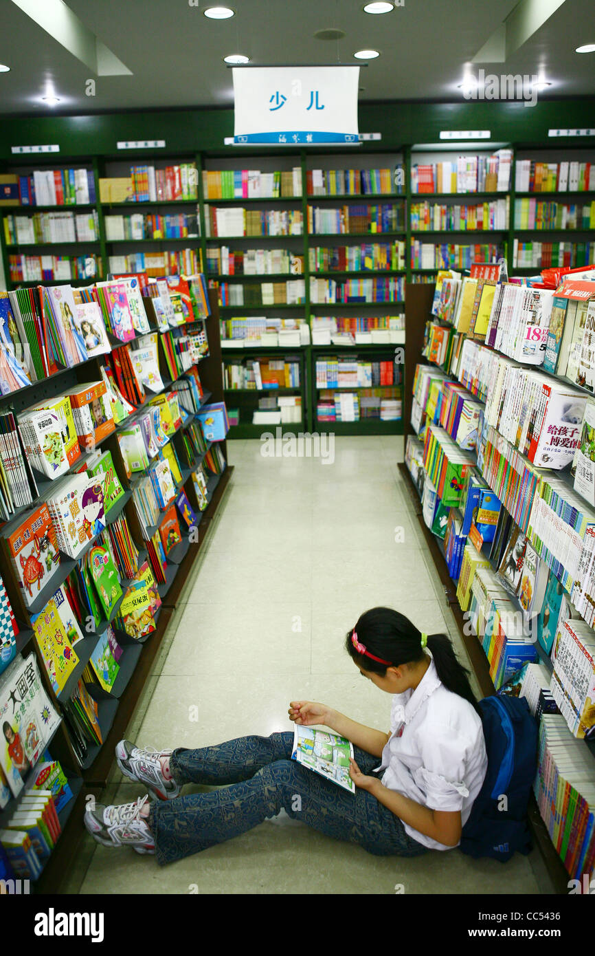 Girl reading book in The Commercial Press, Beijing, China Stock Photo