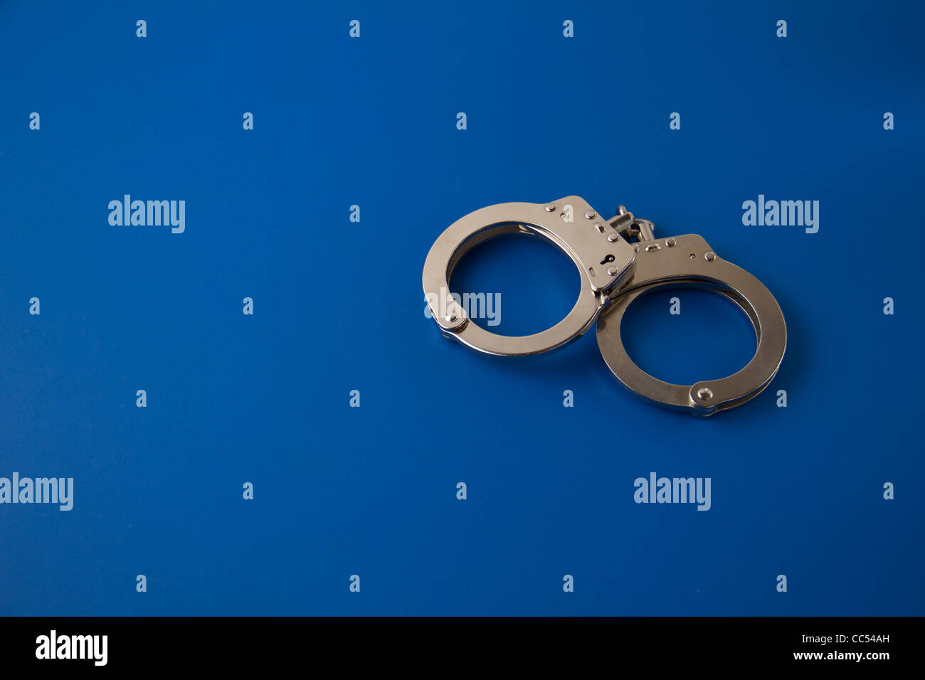 Closed handcuffs on blue background Stock Photo