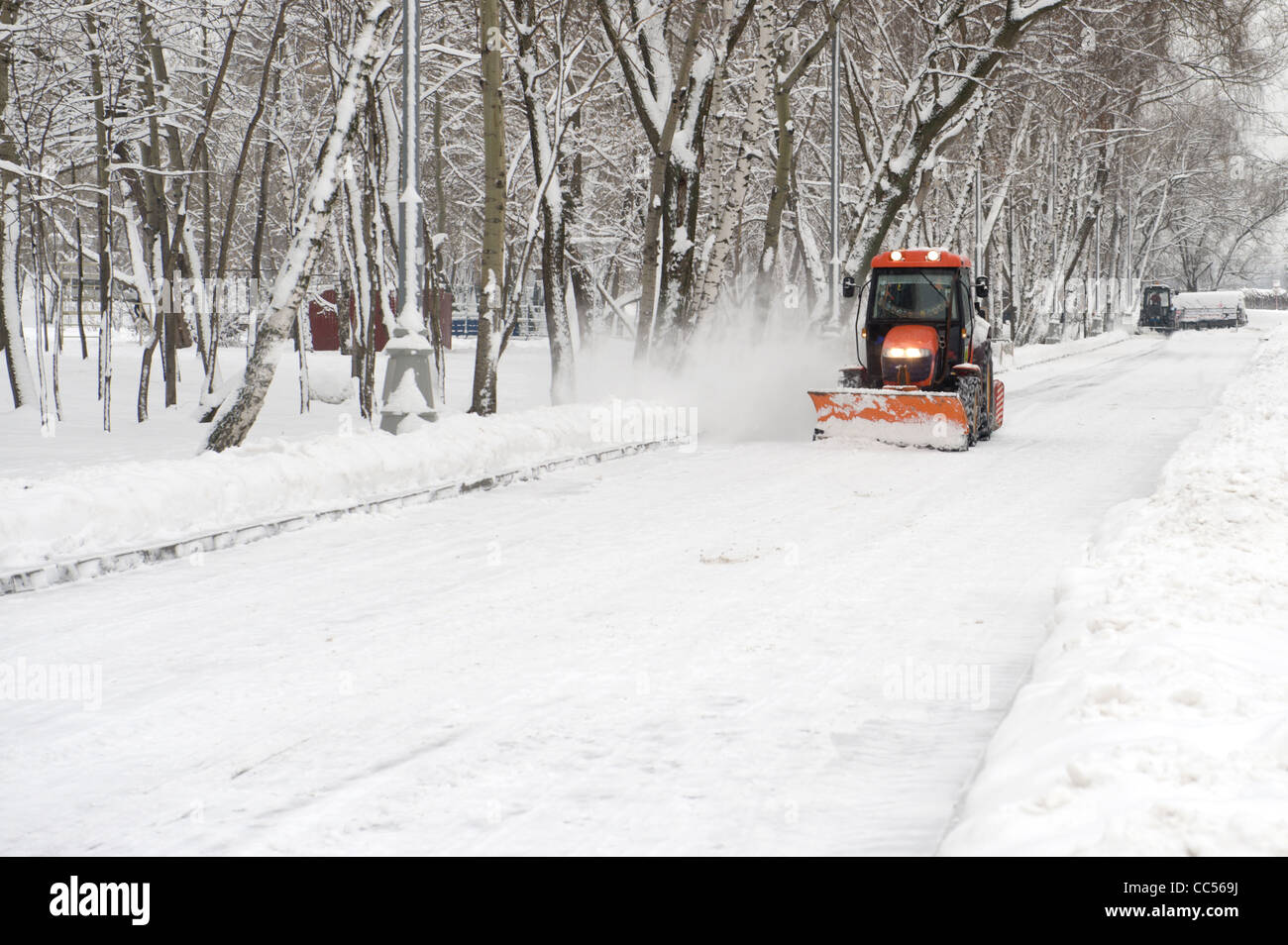 winter snow removal a small tractor in the park Stock Photo Alamy