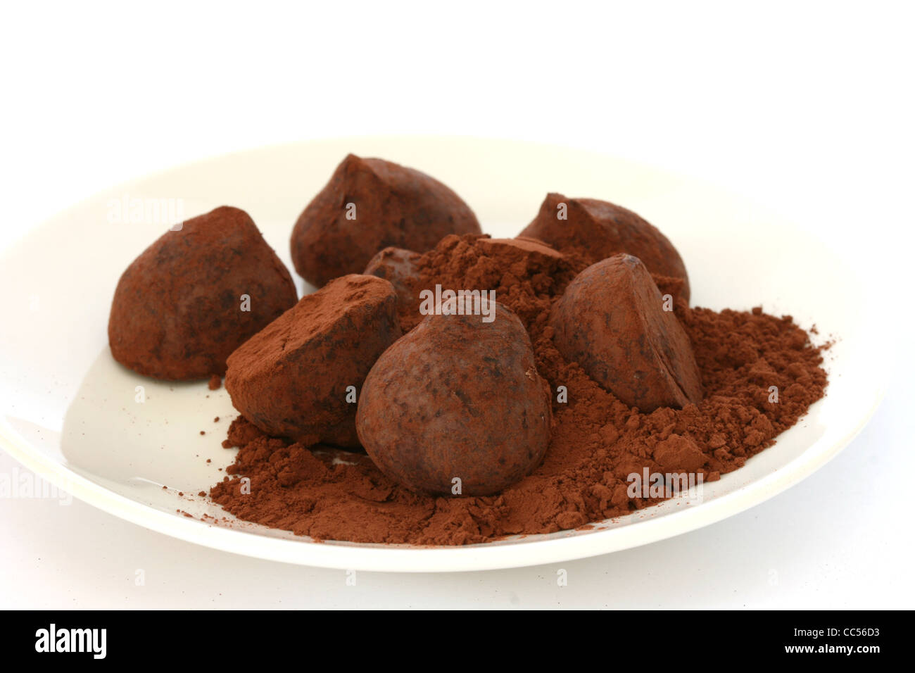 Chocolate truffle pralines sweets covered in cocoa powder on white