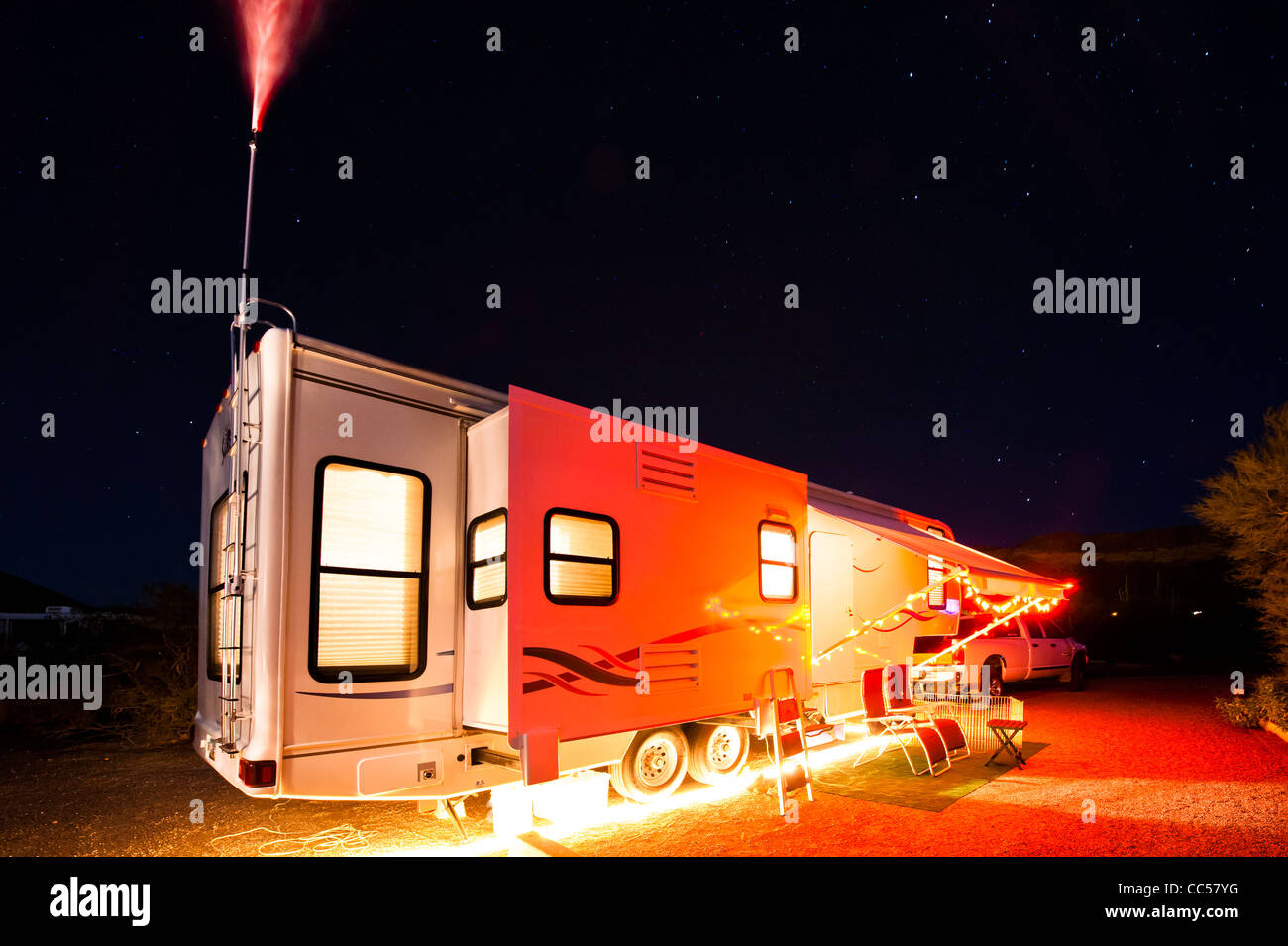 5th wheel travel trailer set up at desert campground. Arizona winter camping is so nice. Nighttime with festive lights. Stock Photo