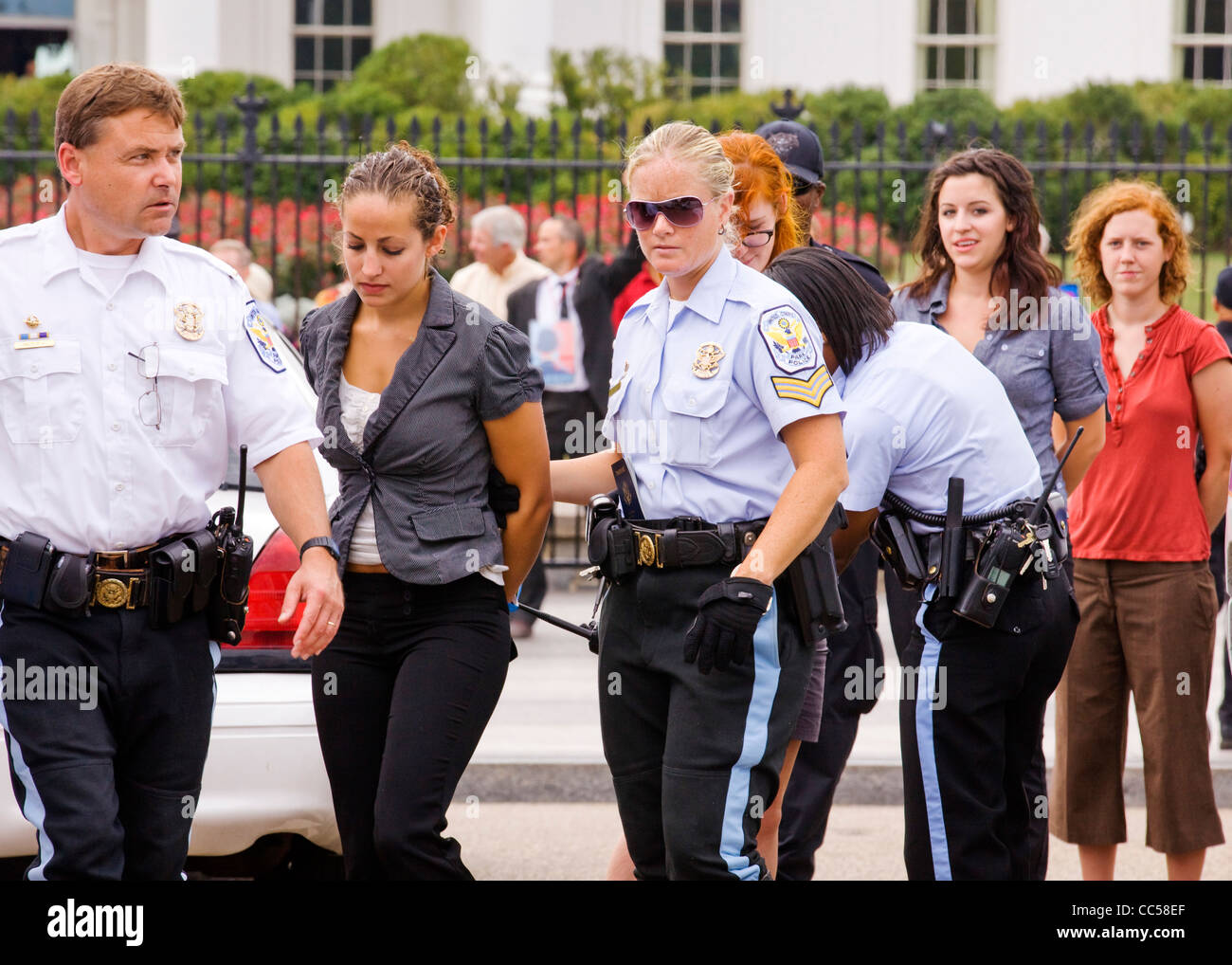 A young female protester is handcuffed and detained for protesting in front of the White House - Washington, DC USA Stock Photo