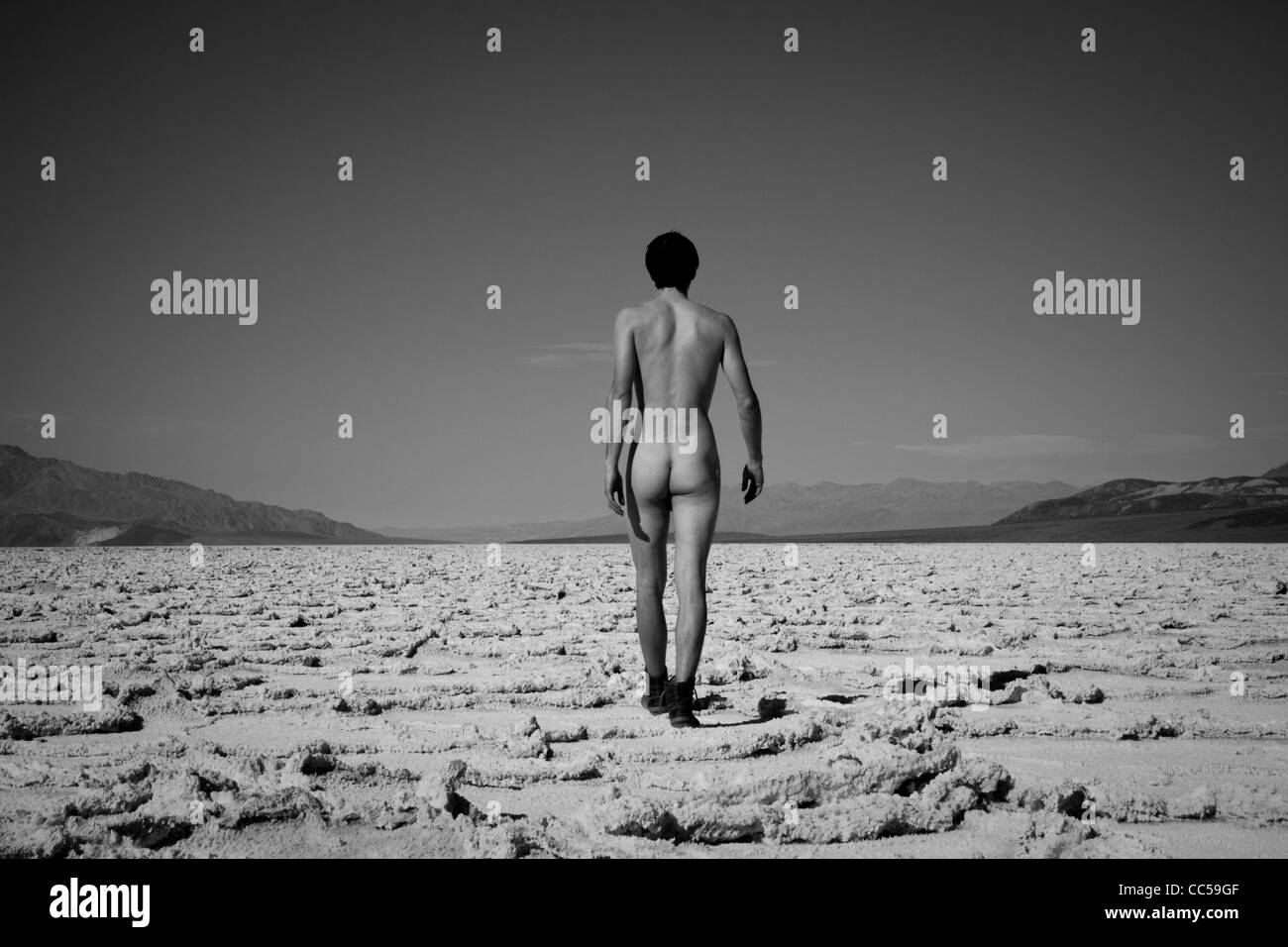 Nude man walking across salt flats Stock Photo - Alamy