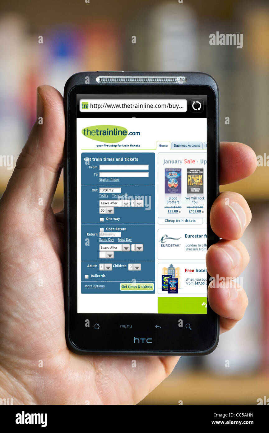 Booking train tickets on thetrainline.com website HTC smartphone Stock Photo