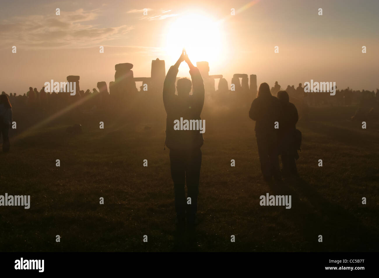 Celebrating the rising of the sun on the morning of the summer solstice at Stone henge, Wiltshire, UK Stock Photo