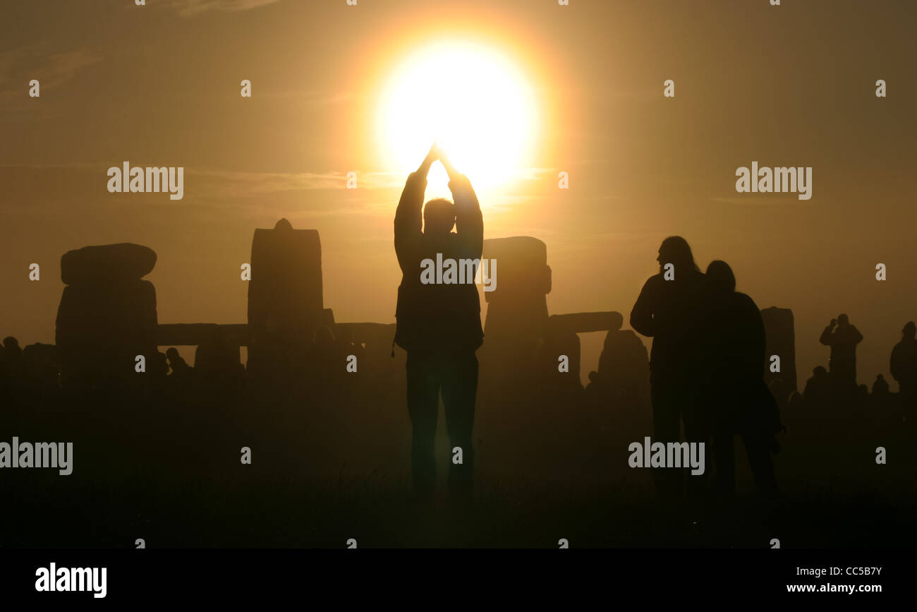 Celebrating the rising of the sun on the morning of the summer solstice at Stone henge, Wiltshire, UK Stock Photo