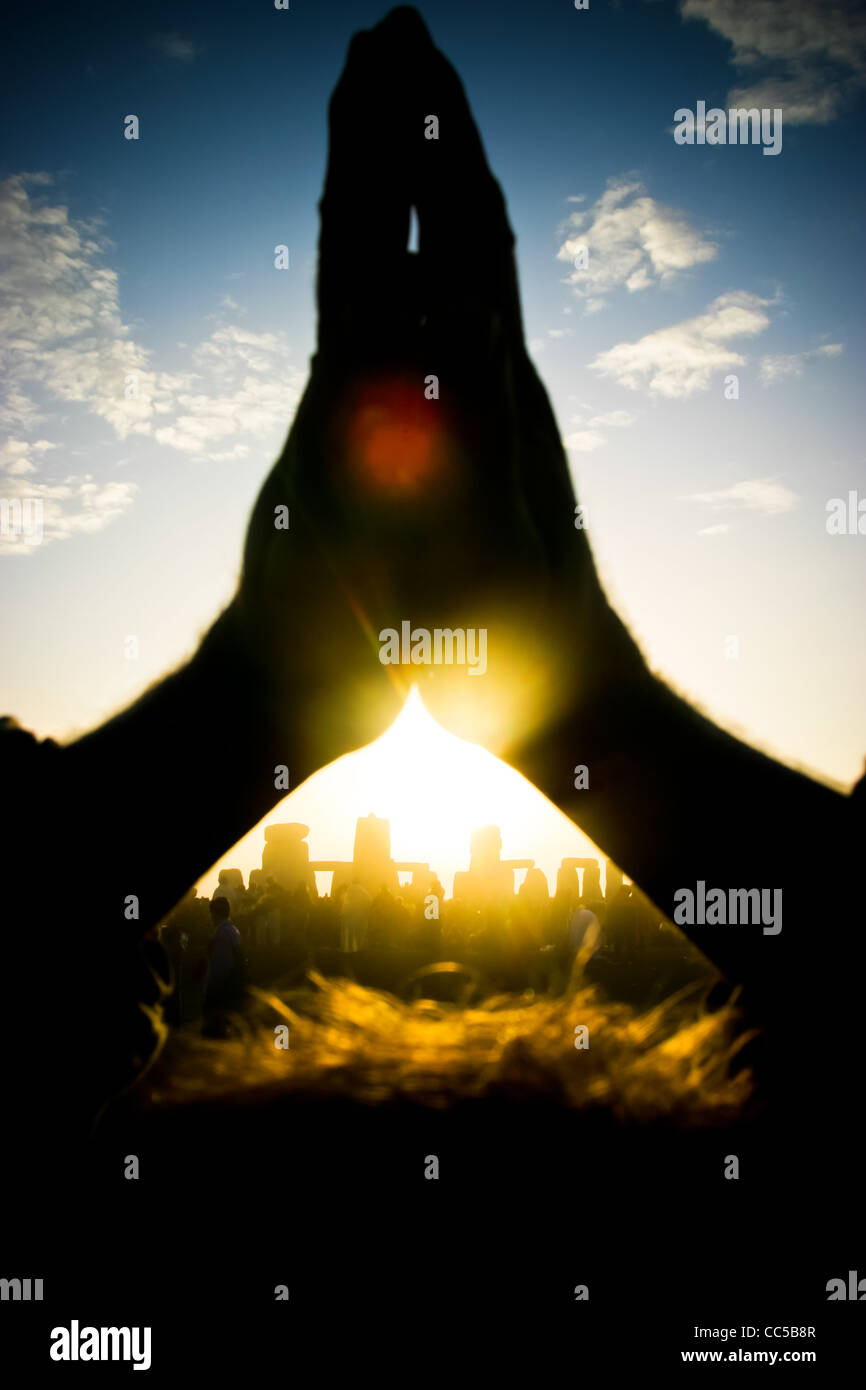 Celebrating the rising of the sun on the morning of the summer solstice at Stone henge, Wiltshire, UK Stock Photo