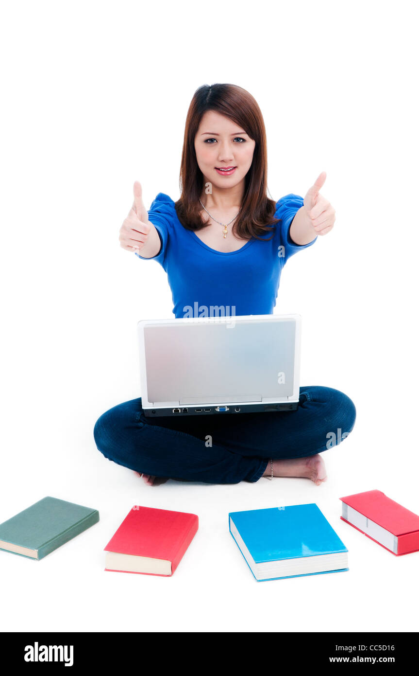 Cute student with laptop and books spread around, giving thumbs up ...