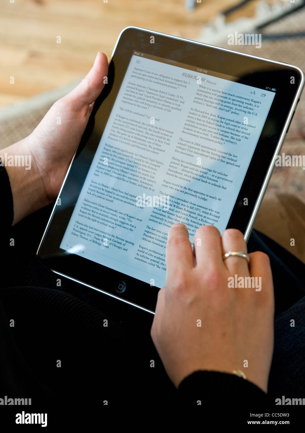 Caucasian woman uses Apple iPad to read USA Today news article Stock Photo