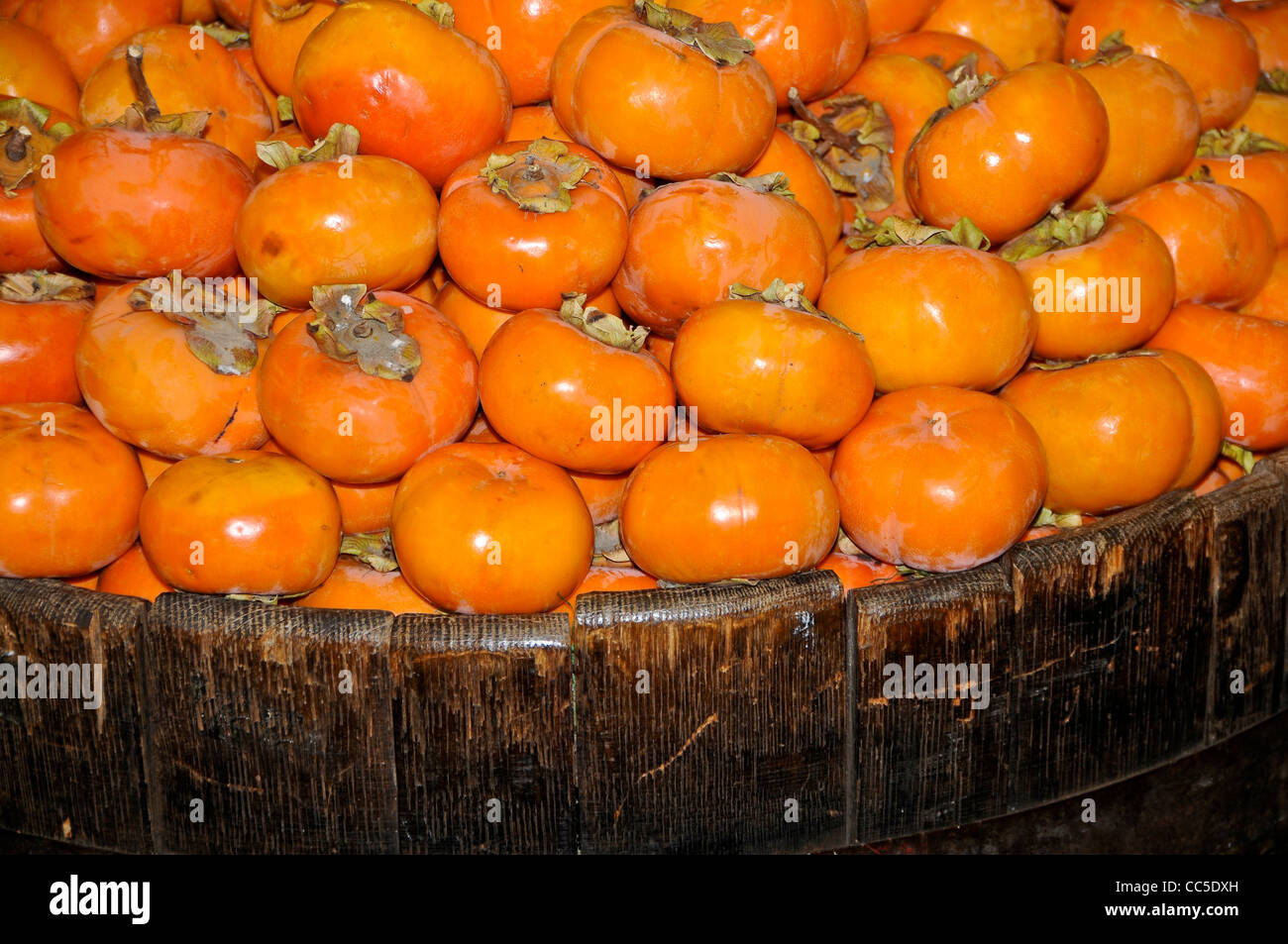 Fuyu Persimmons in Wooden Barrel Stock Photo