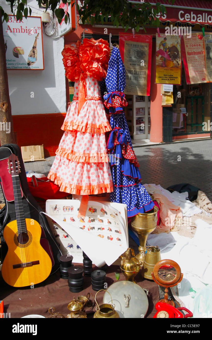 Flamenco dresses and guitar on market stall on famous street market in calle Feria in barrio Macarena, Seville, Spain, Europe Stock Photo