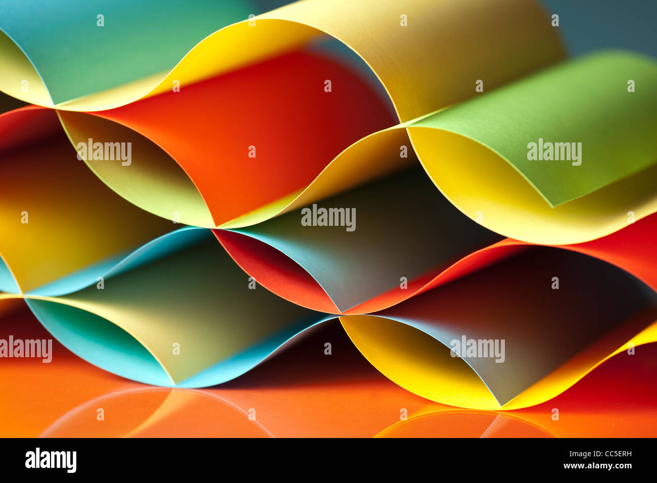 background macro image of colored origami pattern made of curved sheets of paper, with mirror reflexions Stock Photo