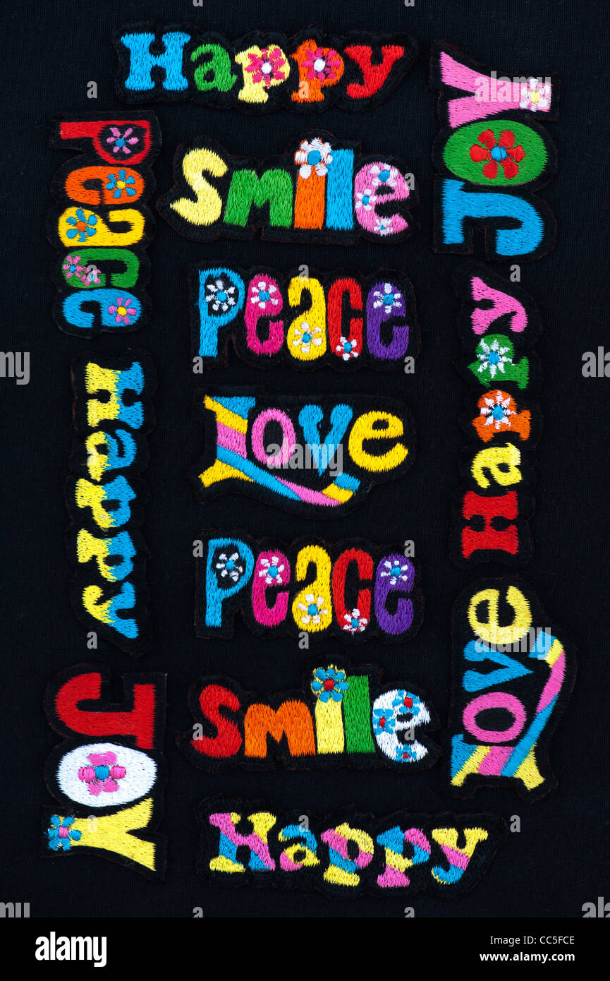 Embroidery iron on patches of Multicoloured Love, Peace, Happy, Smile, Joy and Groovy words on a black background Stock Photo