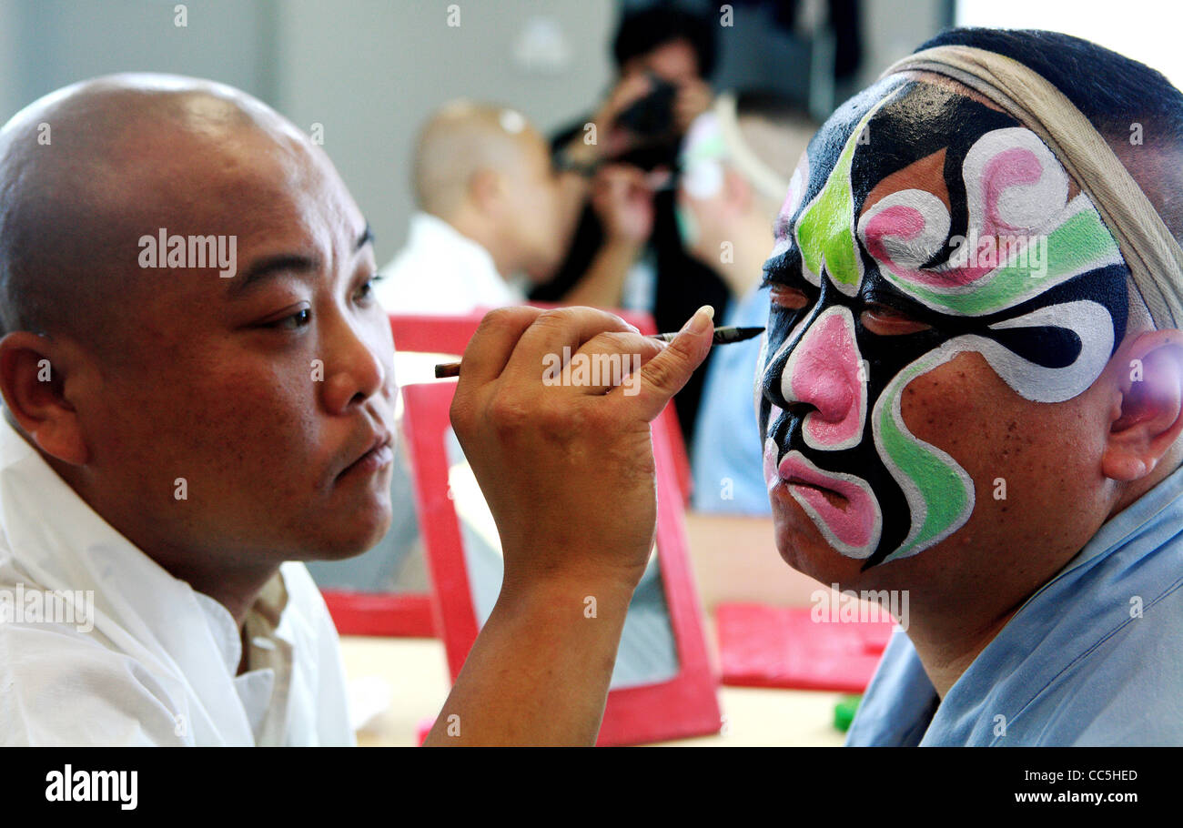 Man painting Peking opera performer's face, Beijing, China Stock Photo