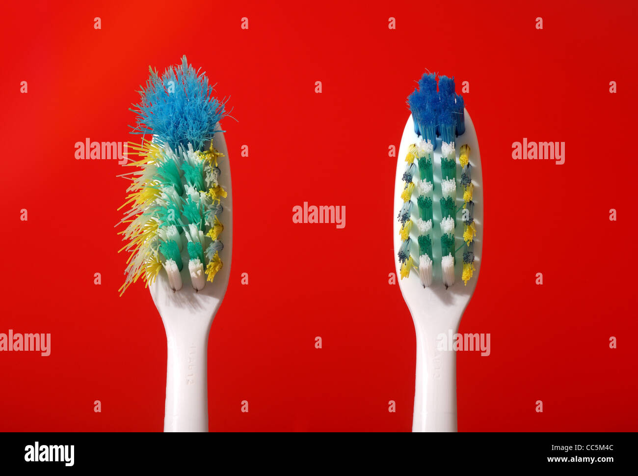 A comparison of a new and a used toothbrush. The brush on the left was used for approximately two months Stock Photo