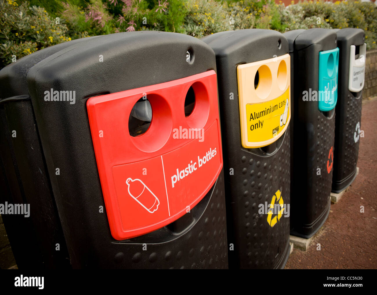 Row of sorted recycling and general waste bins in a UK town centre
