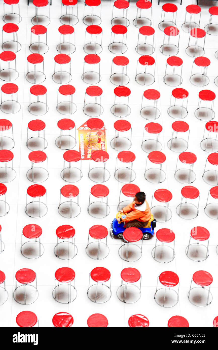 Boy driving his electrocar through abundant seats, Changchun, Jilin , China Stock Photo