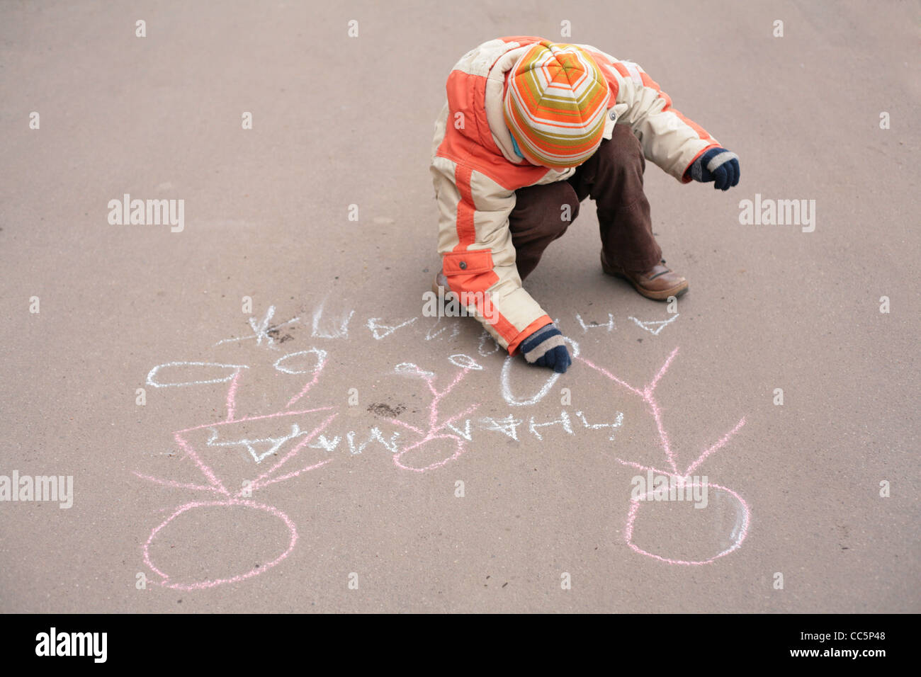 Boy sketches by chalk on asphalt Stock Photo - Alamy