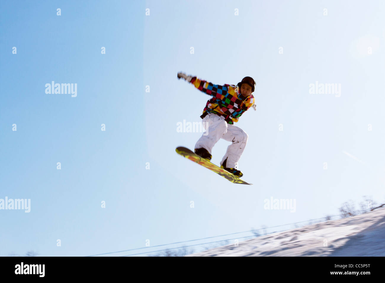 Young man on skateboard in mid-air, Lianhua Mountain Ski Resort, Changchun, Jilin , China Stock Photo