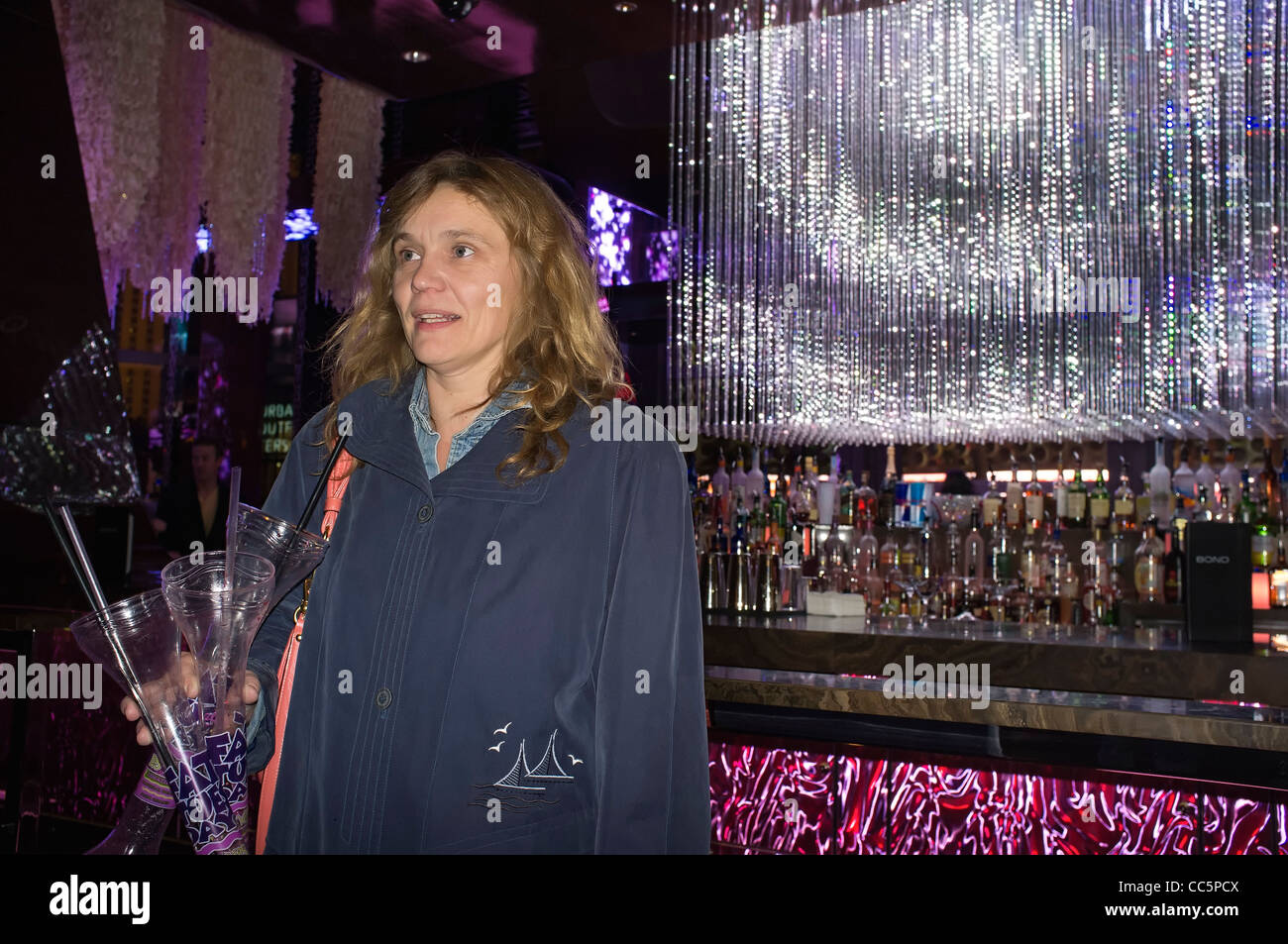 Woman in front of hotel bar holding Fat Tuesday daiquiri drink vase Stock Photo