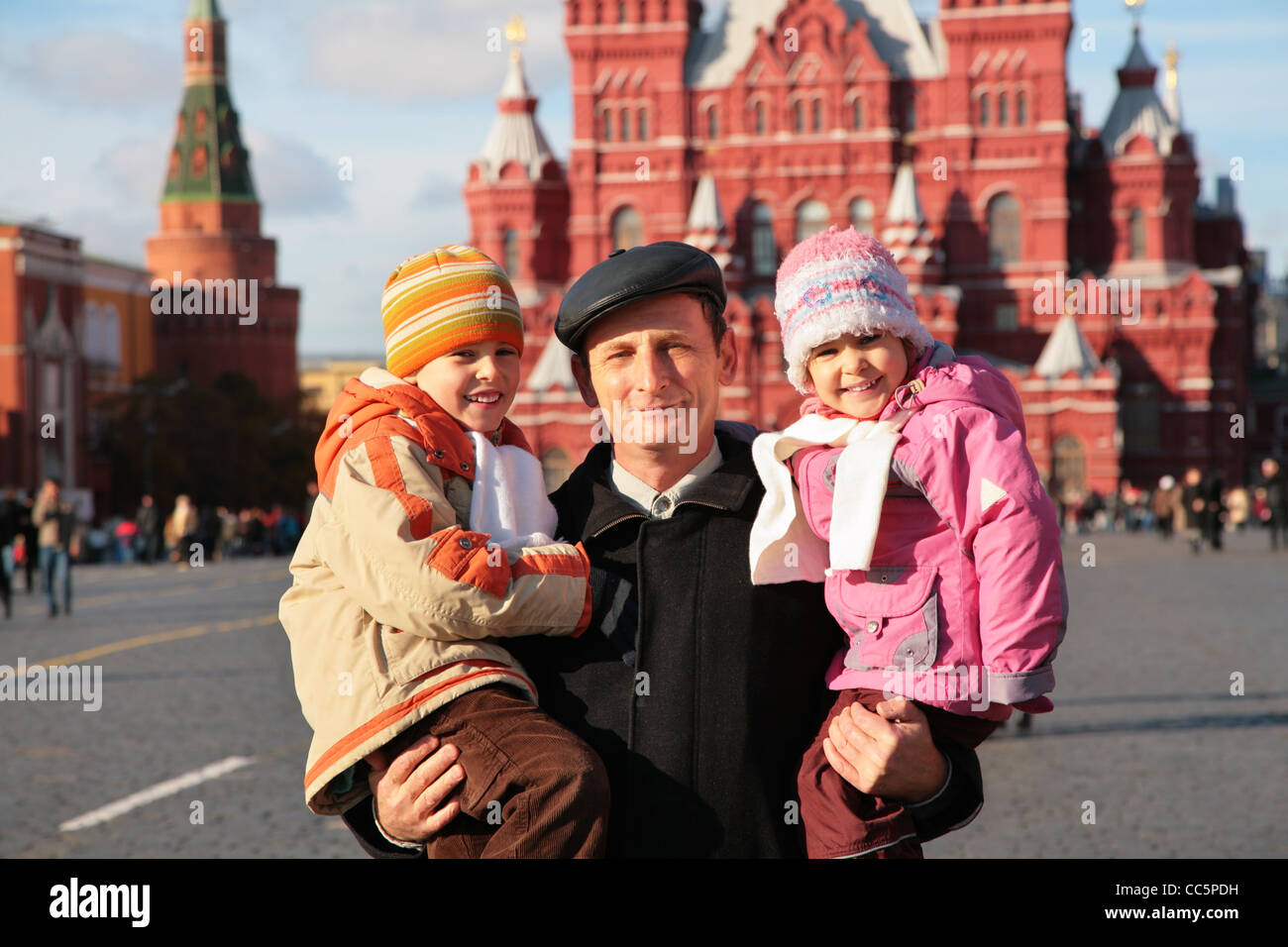 Grandfather with grandson and granddaughter on red square Stock Photo