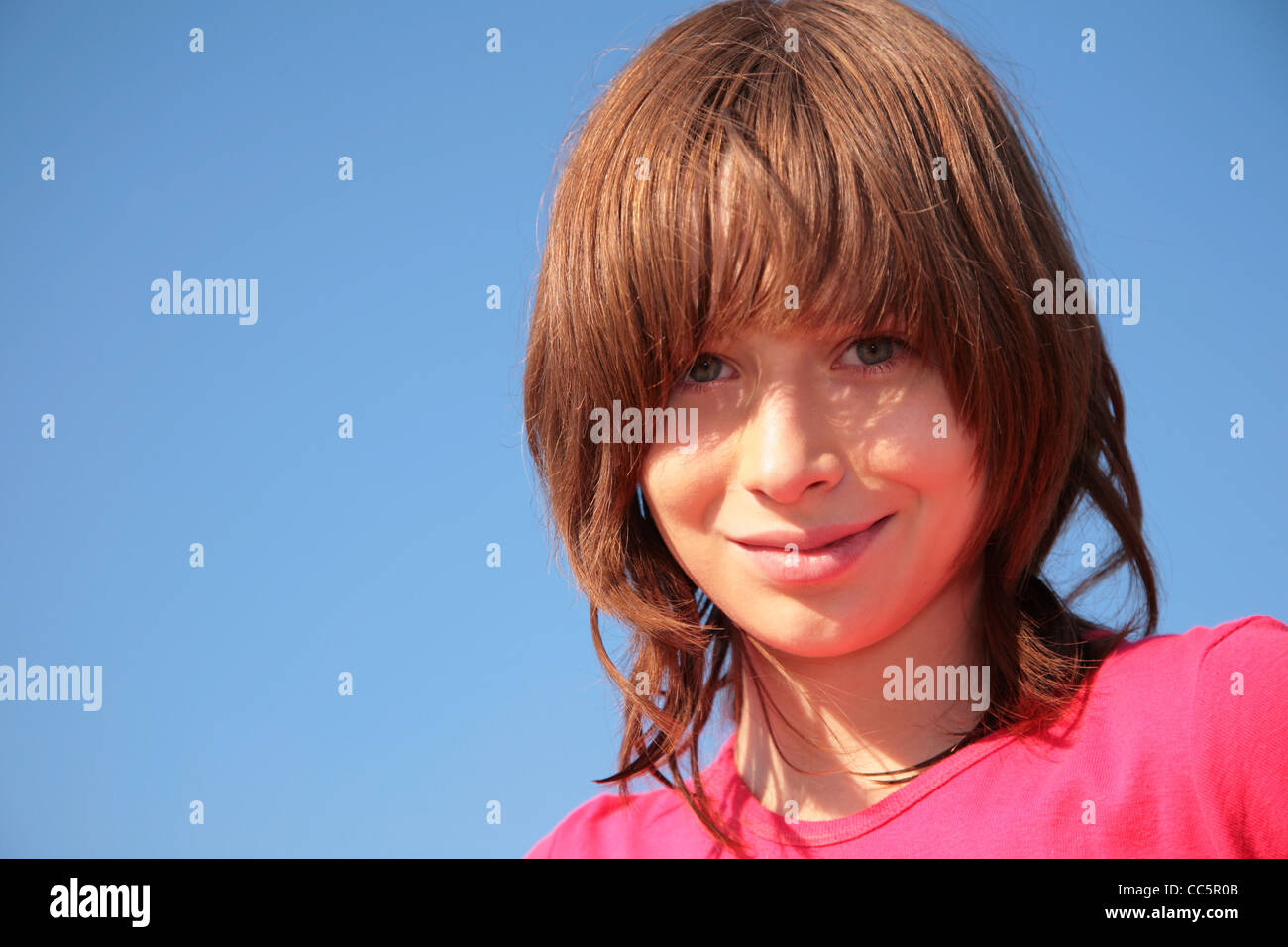 Portrait of young girl on blue sky background Stock Photo - Alamy