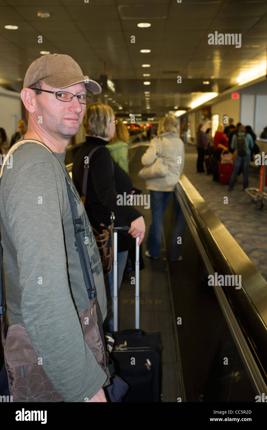 People at the airport using moving walkway travelator Stock Photo